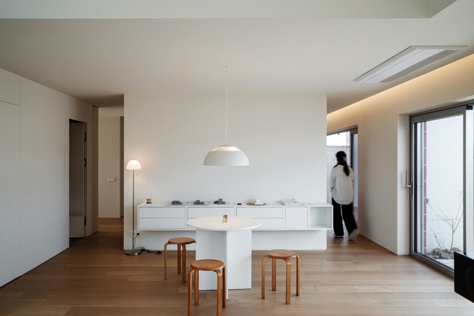 Minimalist living room with natural light and wooden floors in a renovated home